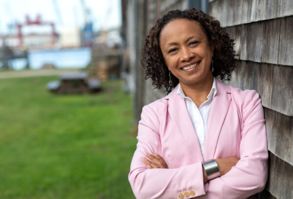 Elsy Cipriani -  smiling standing in pink blazer with arms crossed at waist